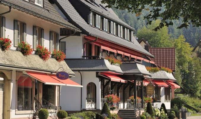 Fassade des Engel Obertal mit roten Markisen, Blumenkästen und dem Schild des „Engel Lädle".